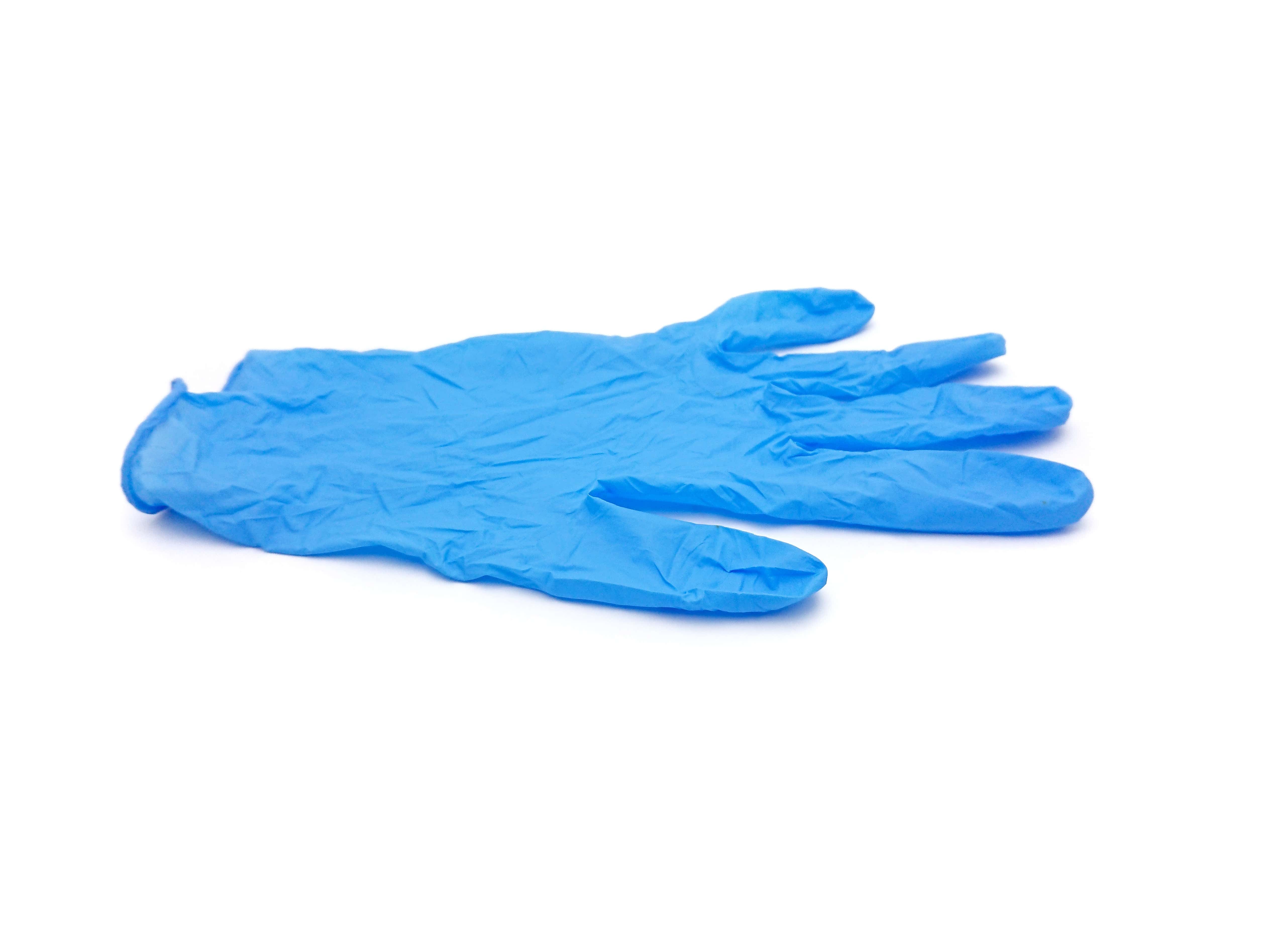 Ein blauer OP-Handschuh liegt auf weißem Hintergrund